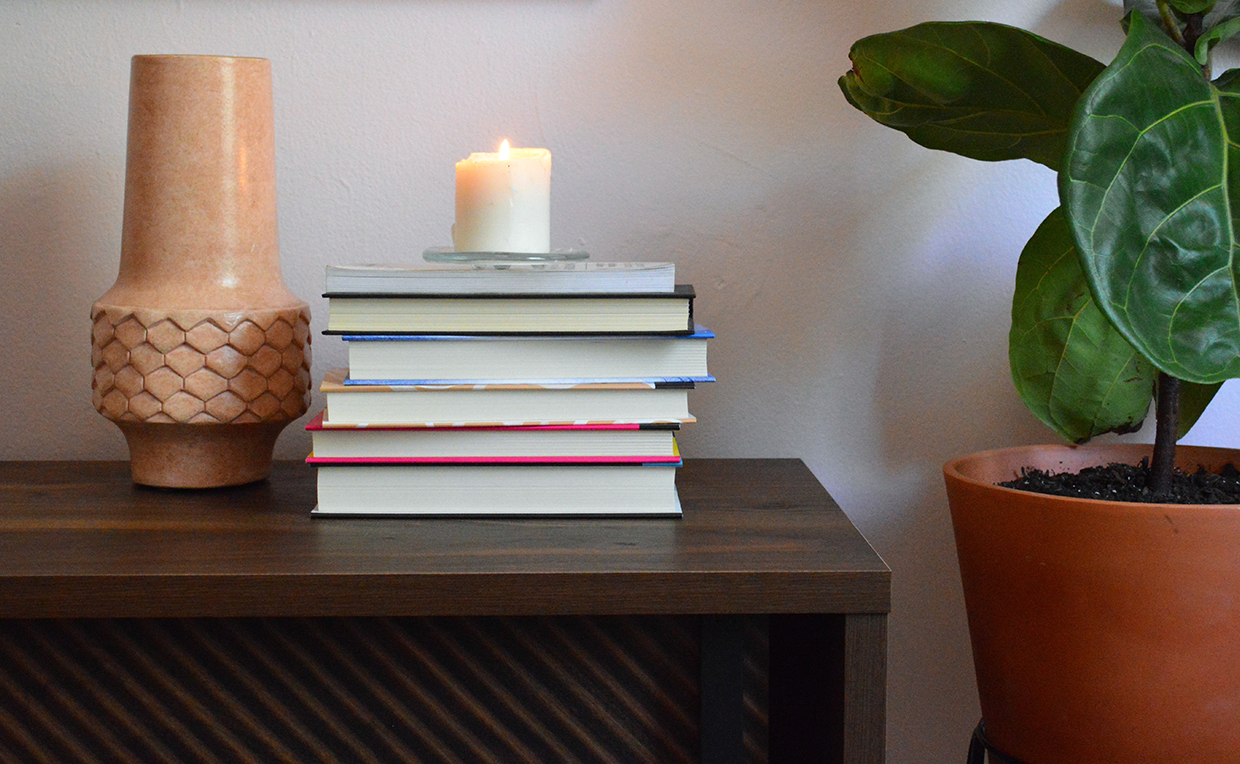 Candles and books on a TV stand
