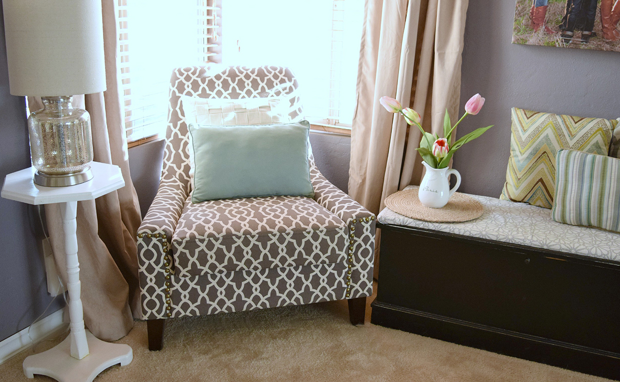 upholstered chair next to side table in the bedroom