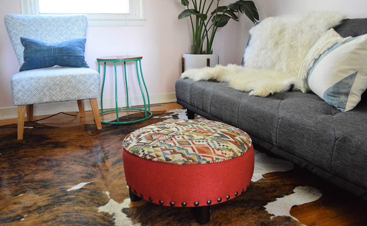 Den with couch, sheepskin blanket, chair and ottomans