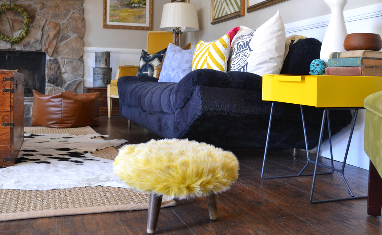 Blue couch against wall with yellow side table